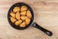 Small fried chebureks in frying pan on wooden table Royalty Free Stock Photo
