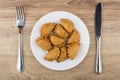 Small fried chebureks in white glass plate, knife and fork Royalty Free Stock Photo