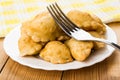 Small fried chebureks in white plate and fork on table Royalty Free Stock Photo