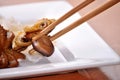 Small fried octopus and wooden chopsticks on white plate. Royalty Free Stock Photo