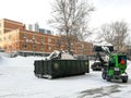Small front-end loaders clear snow from the street and load into a bunker