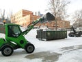 Small front-end loaders clear snow from the street and load into a bunker