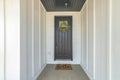 Small front entrance of a house with white board and batten siding