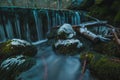 Small frozen water dam at the river spring of Kamniska Bistrica in Slovenia in dry winter time. Cold enchanted waterfall with