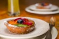 Small fruit tart on a plate and fork Royalty Free Stock Photo