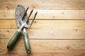 Small gardening shovel and fork on wooden background Royalty Free Stock Photo