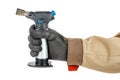 Small gas torch in worker hand in black protective glove and brown uniform isolated on white background Royalty Free Stock Photo