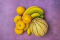 Small Gaul melon with bunch of bananas and yellow peaches