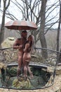 A small gazebo with carved walls and a sculpture of a couple under an umbrella. A cozy place for a pleasant stay