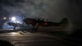 Small general aviation aerobatic single engine piston aircraft parking after sunset. Totally dark with artificial lightning in the