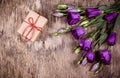 A small gift box and flowers on an old wooden background. Royalty Free Stock Photo