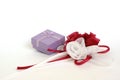 Small gift box with organdy red and white roses on white. Royalty Free Stock Photo