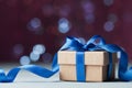 Small gift box or present against magic bokeh background. Holiday greeting card for Christmas or New Year. Royalty Free Stock Photo