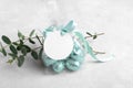 Small gift with chocolate easter eggs in a plastic bag with a bow of mint color ribbon and a round white gift tag mockup