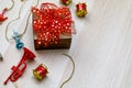 Small gift present box with colorful ribbon bow tie placed on wooden table with small decorative music instruments on Christmas