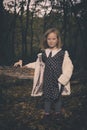 Small girl alone in wild forest in style of halloweeen witch Royalty Free Stock Photo