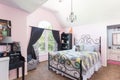 Small girl bedroom in pink and black colors with a bed, dressing table and bookshelf