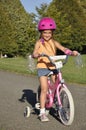 Small girl on a bike with training wheels