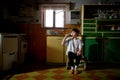 Small girl brushing teeth in kitchen indoors at home, poverty concept. Royalty Free Stock Photo