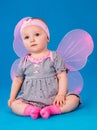 Small girl butterfly wings sitting on the floor