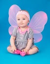 Small girl butterfly wings sitting on the floor Royalty Free Stock Photo