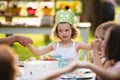 Small girl with cake celebrating birthday outdoors in garden in summer, party concept. Royalty Free Stock Photo