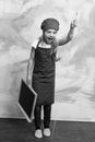 Small girl cook in hat with blackboard. Royalty Free Stock Photo