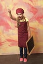 Small girl cook in hat with blackboard. Royalty Free Stock Photo