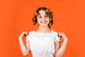 Small girl Curling Hair Using Curlers orange background. Hairdresser salon. Female beauty routine. Adorable child hairdo Royalty Free Stock Photo