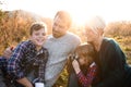 Small girl with family sitting in autumn nature, taking photographs with camera. Royalty Free Stock Photo