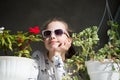 Small girl with flowers. Fashion child wear sunglasses on sunny day. Beauty kid with plant pots in summer or spring. Freshness and Royalty Free Stock Photo