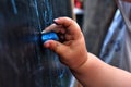 Small girl hand drawing picture on blackboard with blue chalk Royalty Free Stock Photo