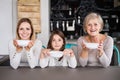 A small girl with mother and grandmother at home. Royalty Free Stock Photo