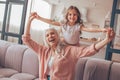 Small girl holding grandmothers hands sitting on the couch at home Royalty Free Stock Photo