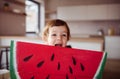 A small girl with large paper toy fruit at home, eating fruit concept.