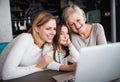 A small girl with mother and grandmother at home. Royalty Free Stock Photo