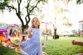 Small girl outdoors in garden in summer, playing with rainbow hand kite. Royalty Free Stock Photo