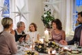 Small girl with parents and grandparents indoors celebrating Christmas.