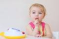 Small girl playing indoors eating candy Royalty Free Stock Photo