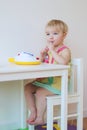 Small girl playing indoors eating candy Royalty Free Stock Photo