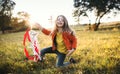 A small girl playing with a rainbow hand kite in autumn nature at sunset. Royalty Free Stock Photo