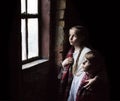 Small girl praying at the window Royalty Free Stock Photo