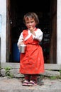 Small girl in red dress, house in mountain, Nepal