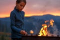 Girl roasting marshmallow on the fire in mountains