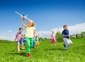 Small girl runs with kids and holds airplane toy Royalty Free Stock Photo