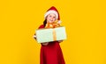 Small girl Santa hat hold gift box. Kid hold present box yellow background. Merry Christmas and happy holidays. Dreams Royalty Free Stock Photo