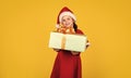 Small girl Santa hat hold gift box. Kid hold present box yellow background. Merry Christmas and happy holidays. Dreams Royalty Free Stock Photo