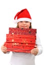 Small girl in Santa's hat carrying three presents Royalty Free Stock Photo