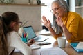 Small girl with senior grandmother doing maths homework at home. Royalty Free Stock Photo