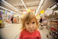 Small girl sit in shoppingcart in supermarket